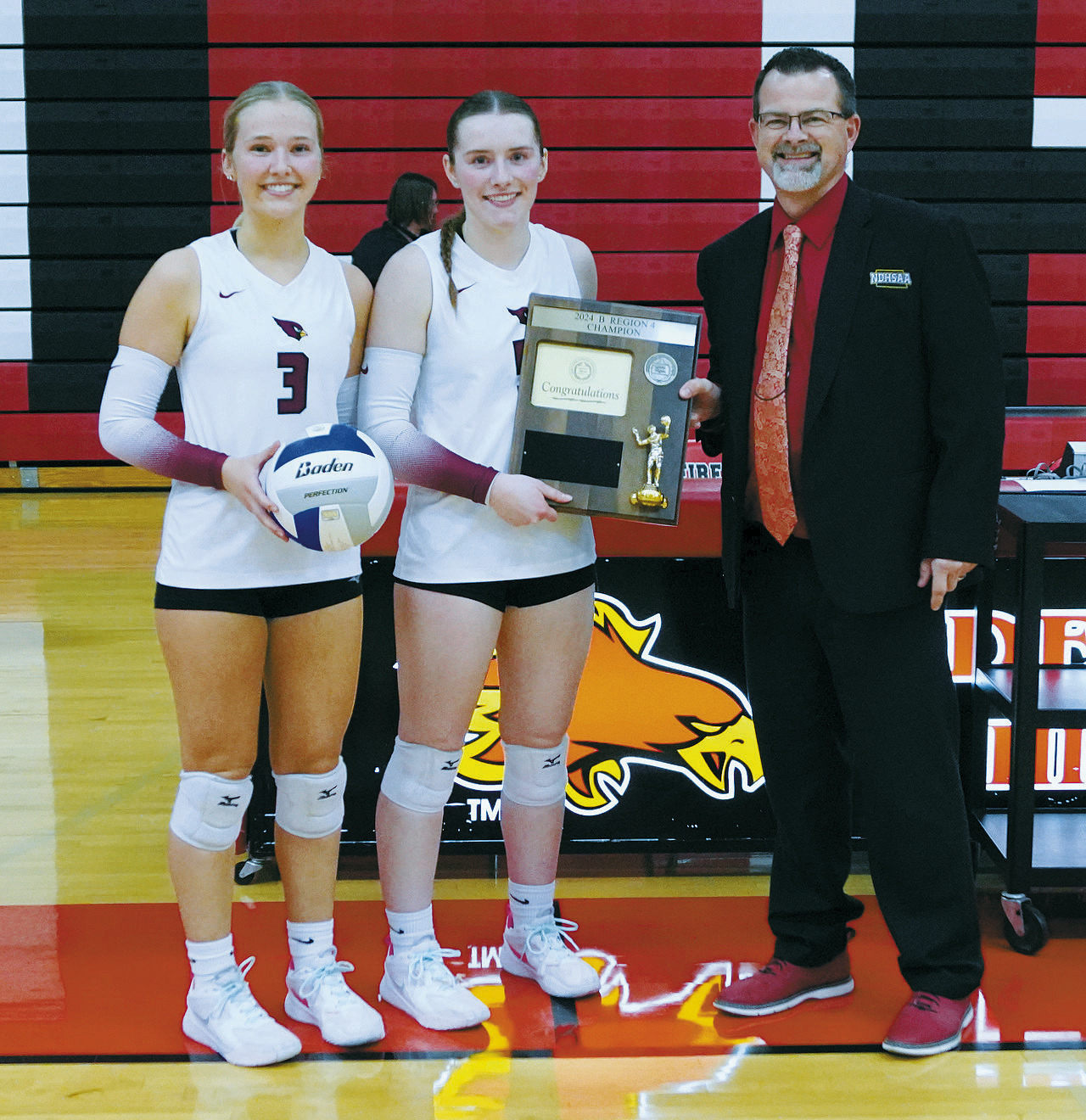 Senior Team Captions Payton Hall and Meredith Romfo accept the Championship Plaque and Game Ball. Photo by Larry Stokke.