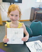 Ava Morrison with her owl she used the gridscale method to draw.