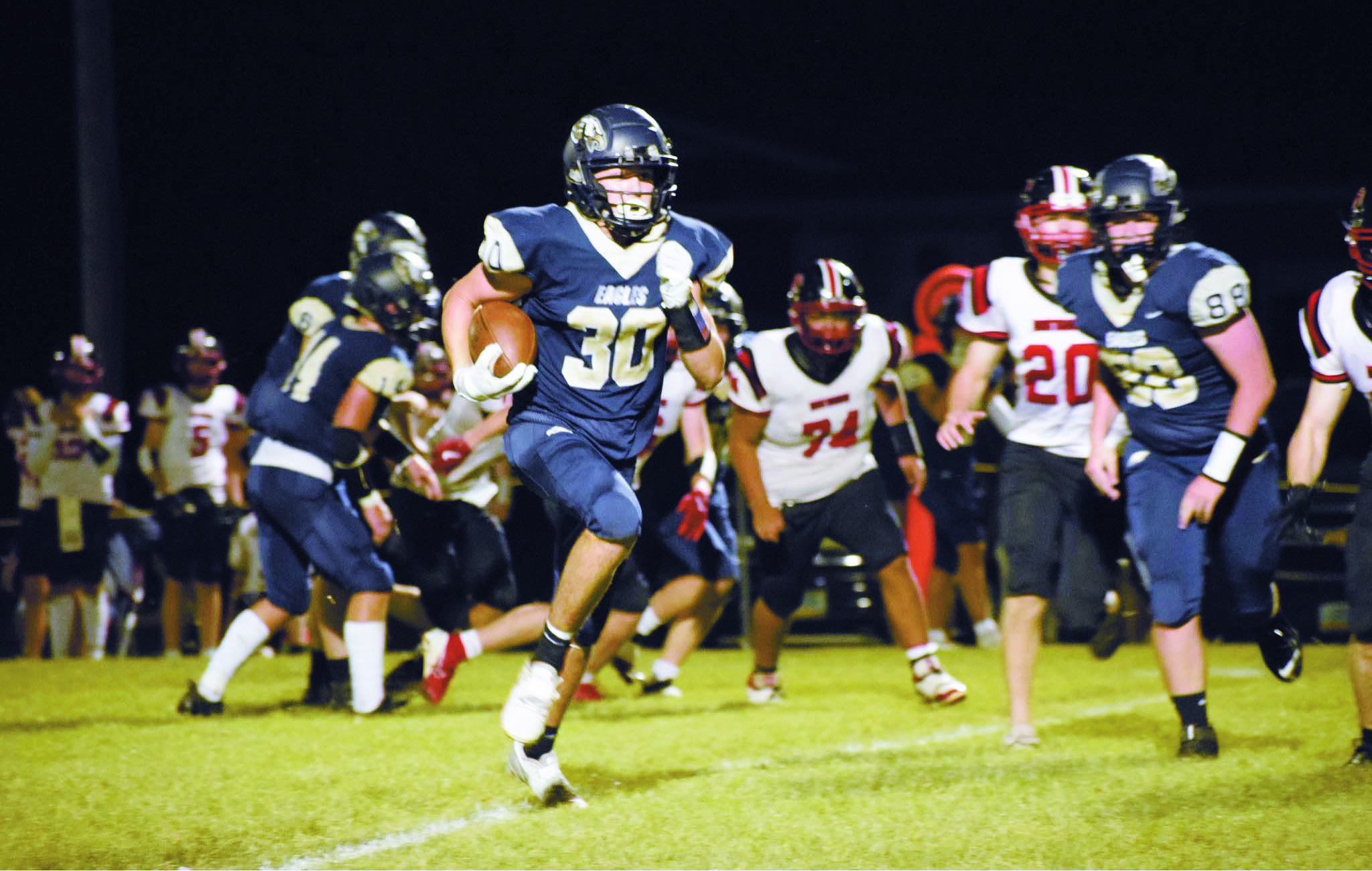 North Border’s Brody Berg (#30) runs the ball as David O'Connor (#88) keeps the path clear. Photo by Rebecca Davis.