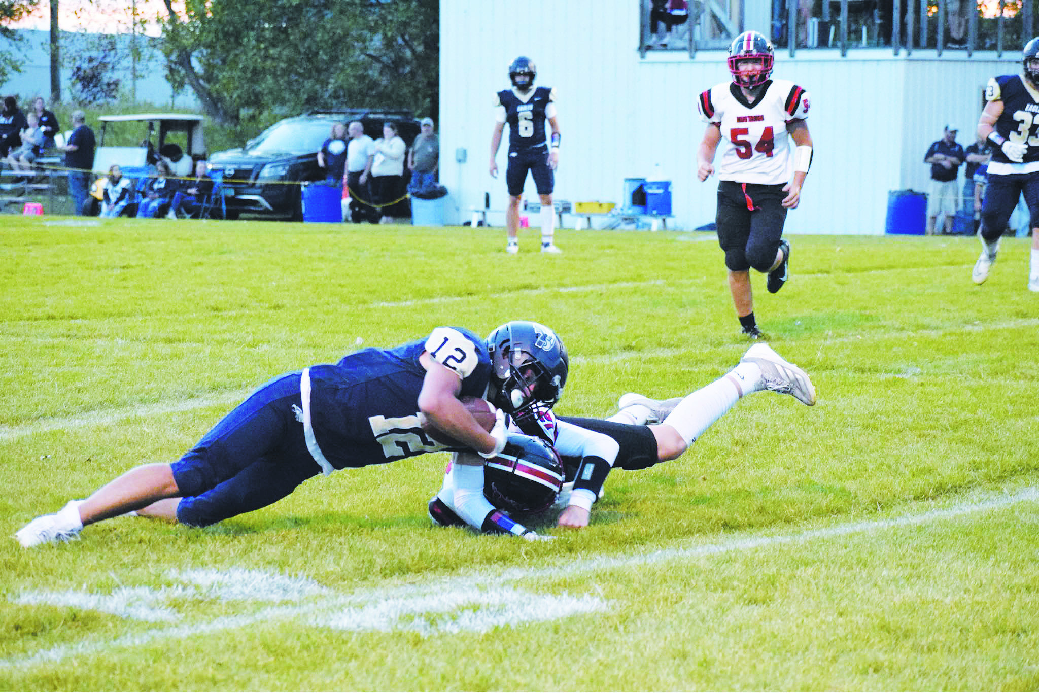 Weston Cosley (#12) holds the ball tight despite a hit. Photo by Rebecca Davis.