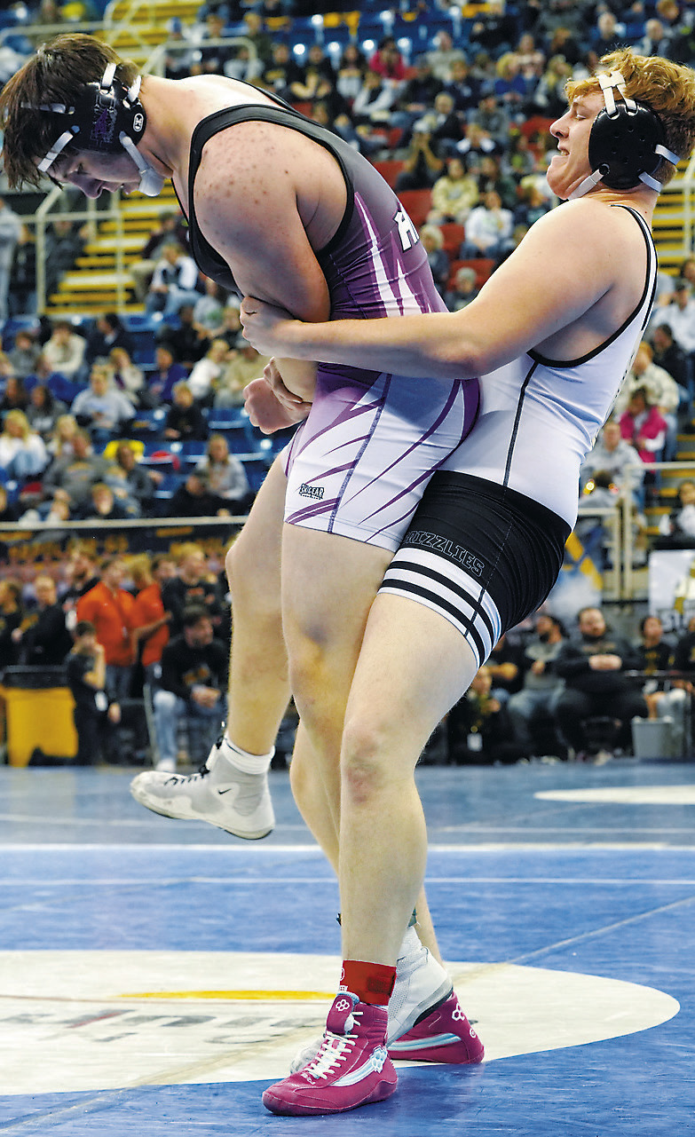 Denton Kaercher powers his man up in the air and takes him to the mat at the State Wrestling Meet. Photo by Larry Stokke.