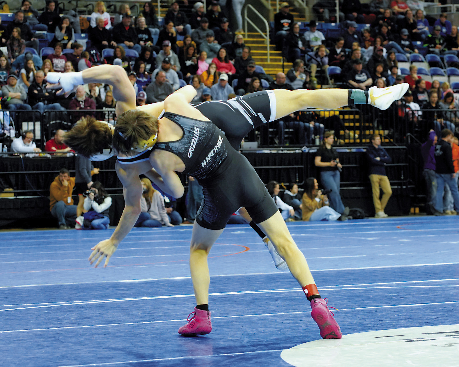 Oscar Martinez takes his opponent off his feet and powers him to the mat in the 127 lbs. weight class. Photo by Larry Stokke.