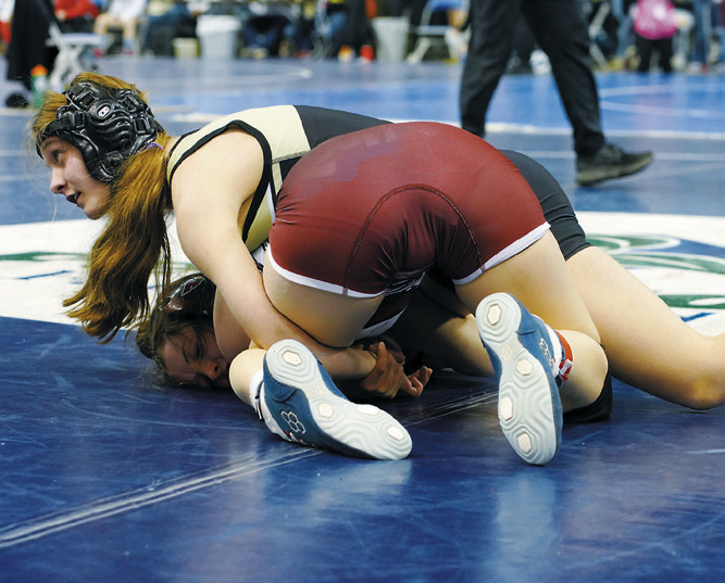Jaelyn Carignan wraps up her opponent and looks over at Coach Brodeurs. Photo by Larry Stokke.
