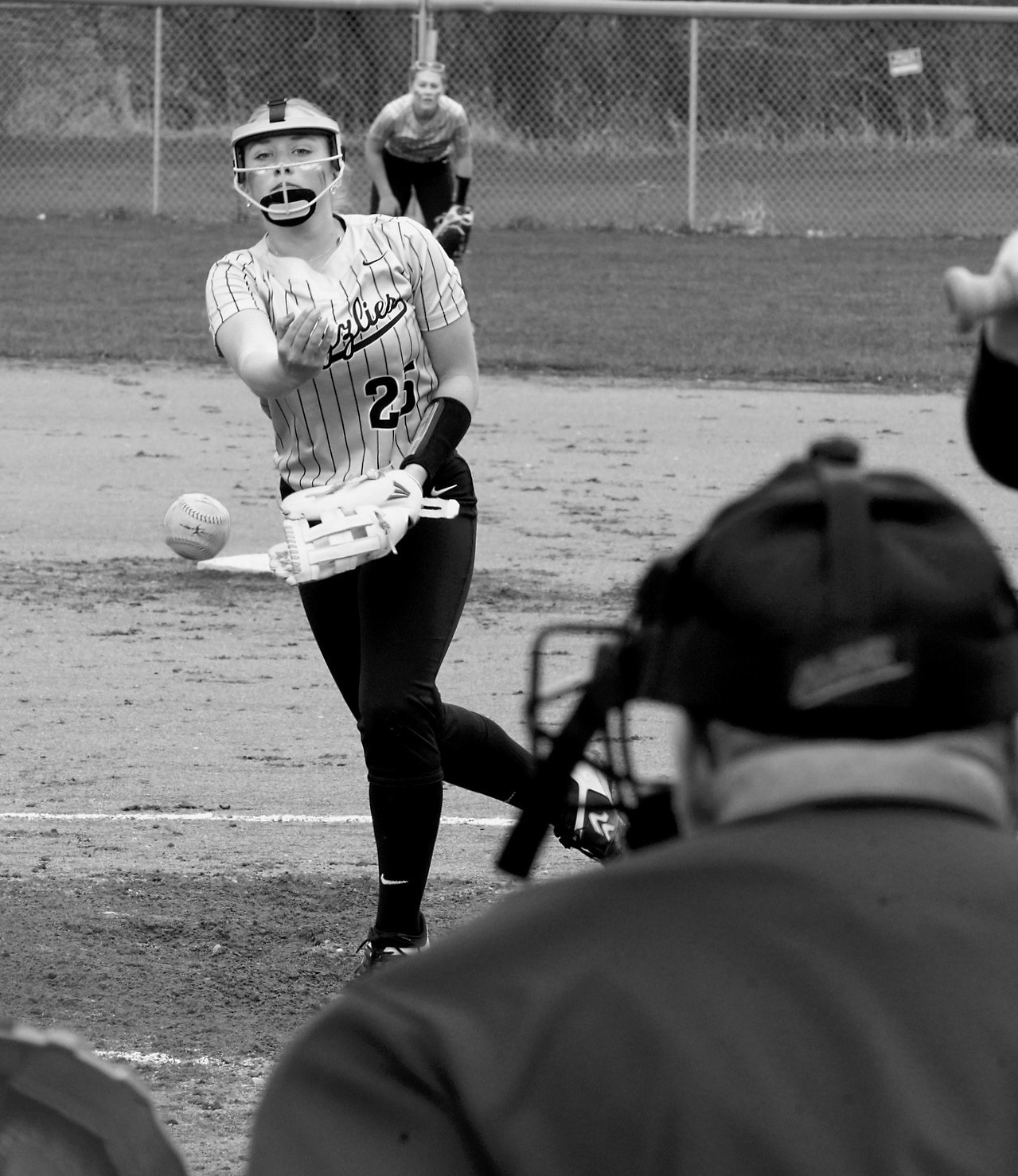 With the umpire watching closely, Sara Jenson sends a strike across the plate in Minto on May 1. Photo by Larry Stokke.