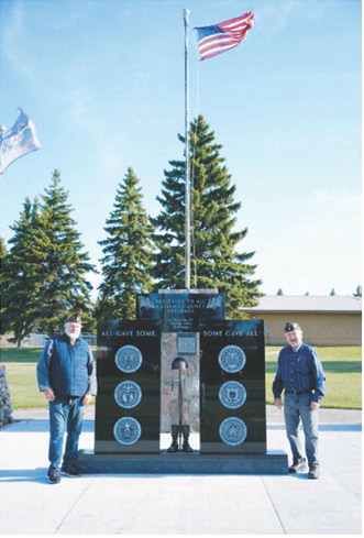 Fellow Post 98 members Bob MacDonald (left) and Harvey Metzger (right) stand in front of the new monument. Photo by Larry Stokke