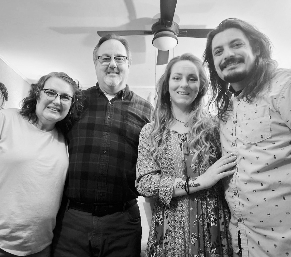 Mom, Joel, me, and Phil posing for a photo on Thanksgiving.