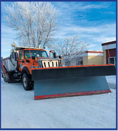 A DOT snowplow is parked outside the front door of Langdon Area Elementary School. Submitted photo.