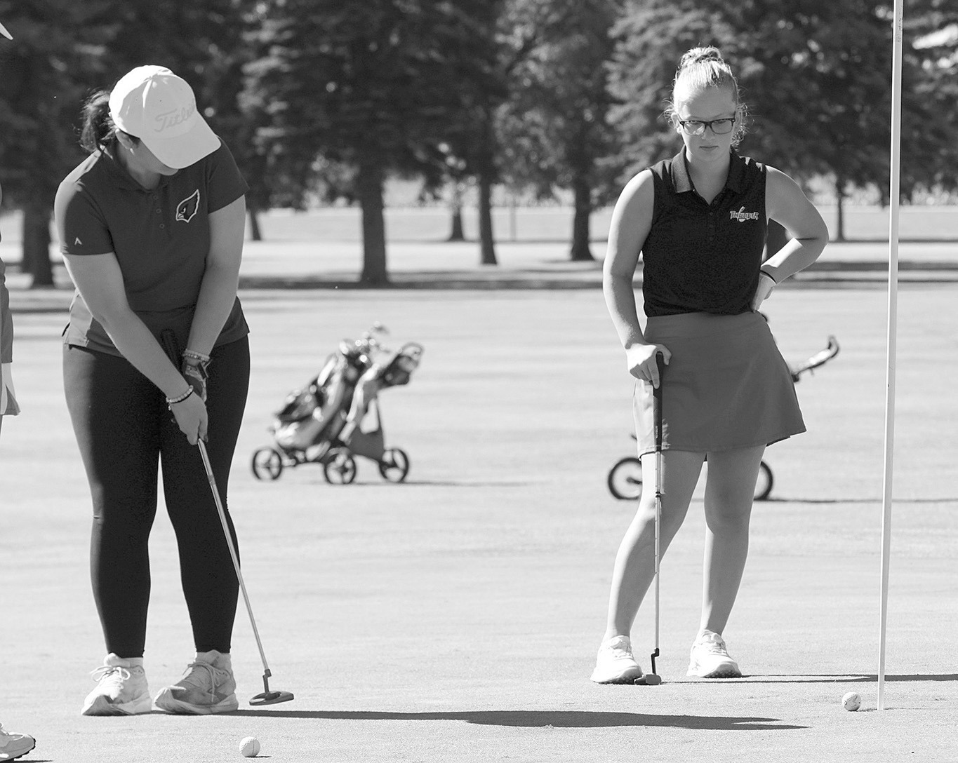 Kynlee Pengilly drops a putt into the cup during the season-opening golf meet Aug. 7 in Larimore. Photo by Larry Stokke.