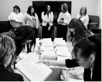 Members of the sponsoring committee for a proposed ballot measure to make public school meals free watch as staff with the North Dakota Secretary of State’s Office count petition signatures on April 9, 2026. (Photo by Mary Steurer/North Dakota Monitor)