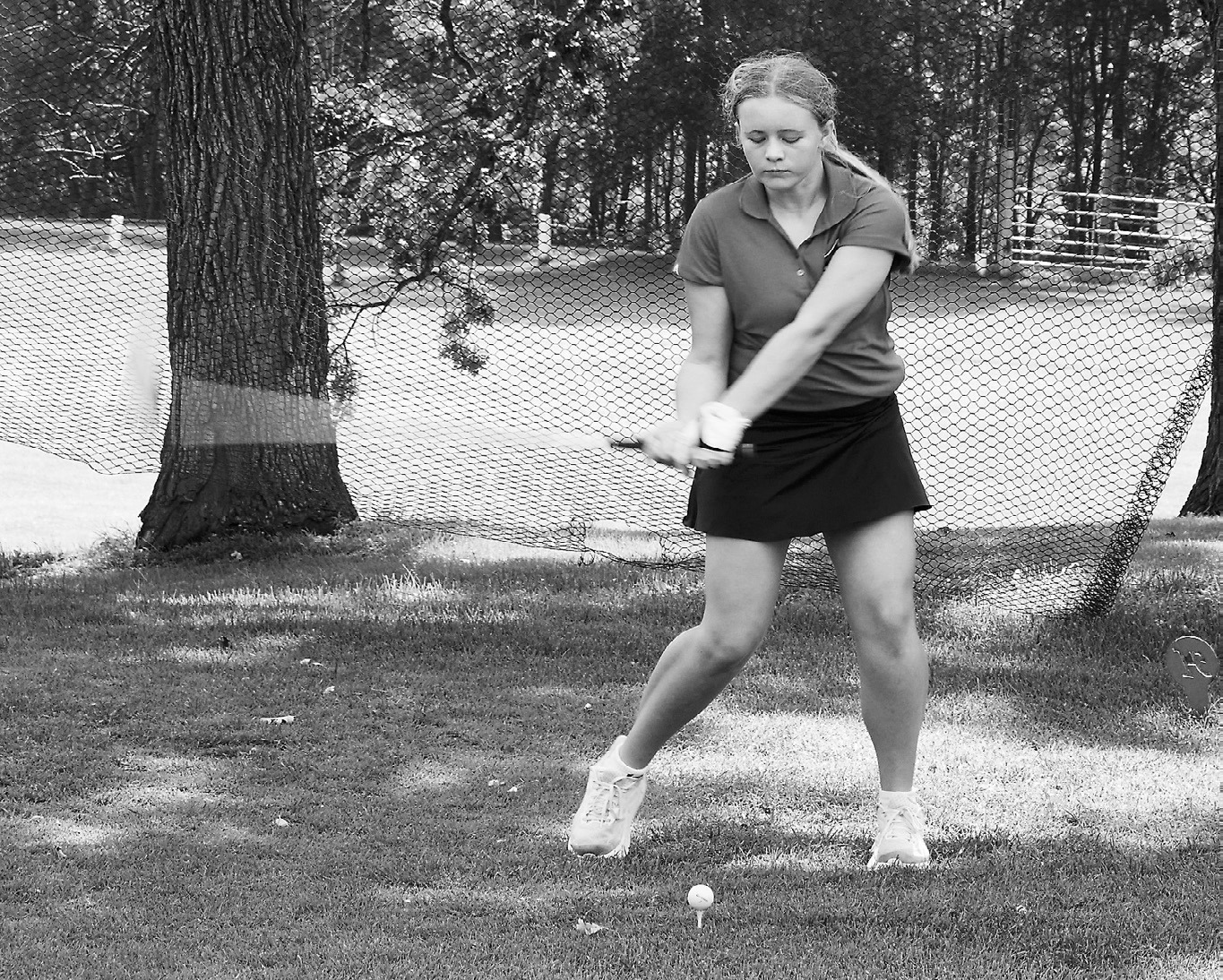 Harper Jacobson's club turns into a blur as she tees off. Photo by Larry Stokke.