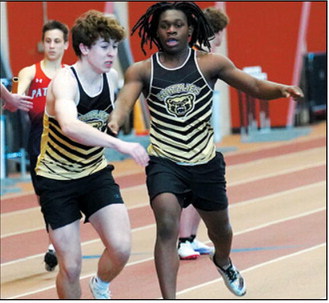 Micah Dutch hands the baton to Logan Heuchert as they, along with teammates Asher Crosby and Kylan Schafer, placed fifth in the 4x300 relay. Photo by Larry Stokke