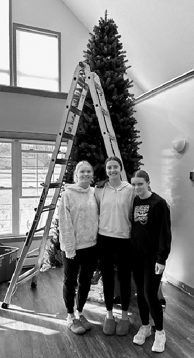 Jacy, Jaelyn, and Hannah pose for a photo while decorating trees at PNC.