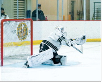 Ryder Moser makes a great glove save in the championship game in Watford City on March 6. Photo by Larry Stokke