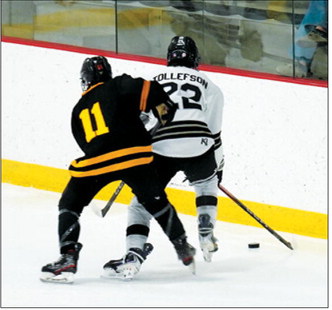 Christian Tollefson takes control of the puck along the glass and takes it up the ice to the Grand Forks end. Photo by Larry Stokke