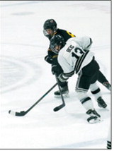 Senior Ben Berg takes the puck away and brings it up the ice. Photo by Larry Stokke