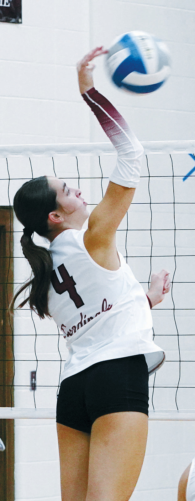 Avery Lorenz sends the ball over to add a point to the Card's win. Photo by Larry Stokke.