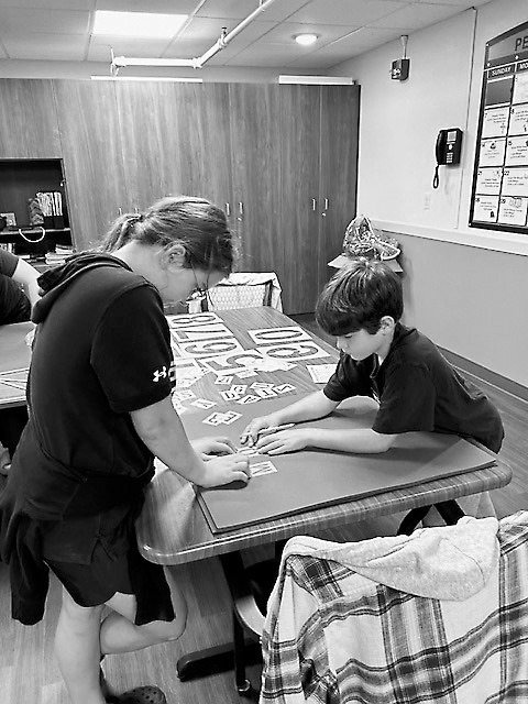 Students Corbyn and Caleb work on their homecoming posters together.