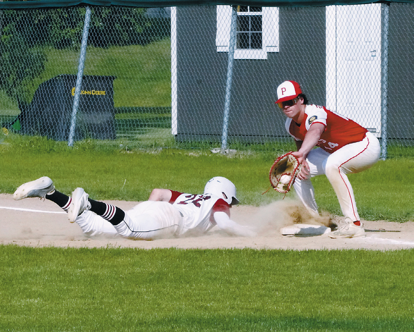 Mason Romfo slides back to first base against MayPort. Photo by Larry Stokke.