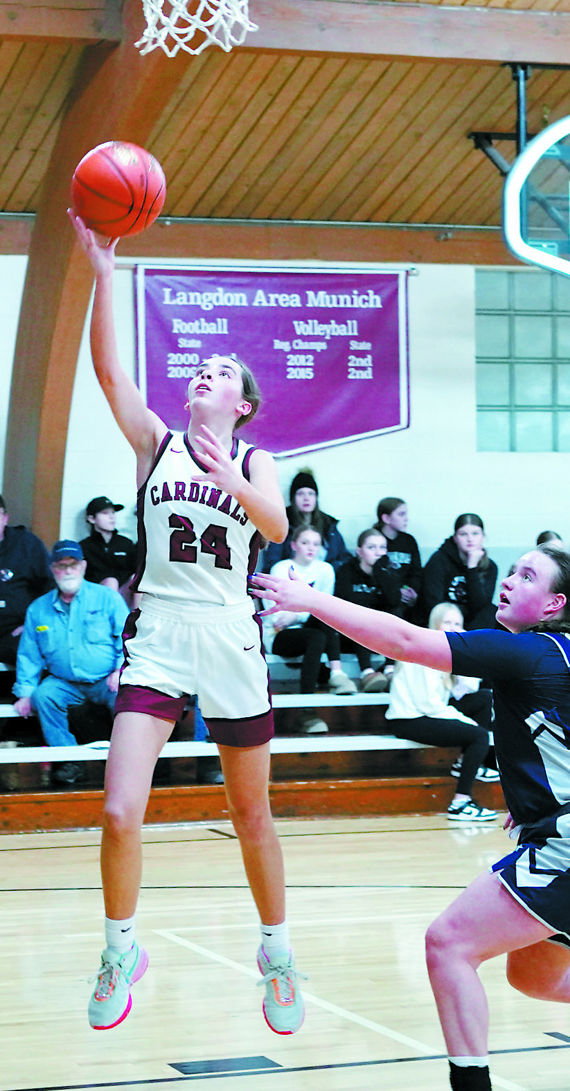 Avery Lorenz drops in a layup at the game against the Cougars. Photo by Larry Stokke.