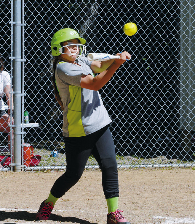 Kayanna Petri eyes the ball before sending it flying to get on base. Photo by Larry Stokke.