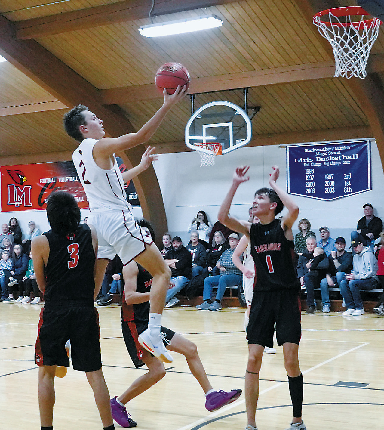 Tanner McDonald drives the ball to the basket and finger rolls it into the hoop. Photo by Larry Stokke.