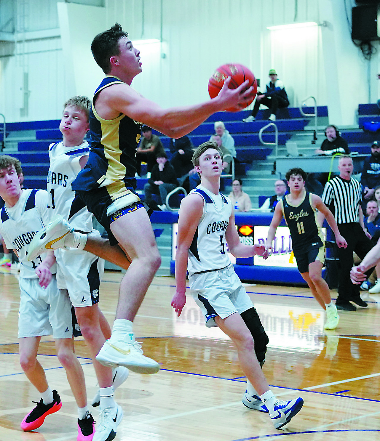 Brody Berg flies through the lanes and drops in a basket to add to his 14-point night against North Prairie. Photo by Larry Stokke.