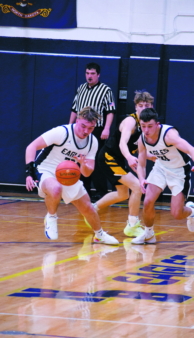 Kade Schafer takes the ball back down the court followed by Brody Berg after a steal. Photo by Ashley Schafer.