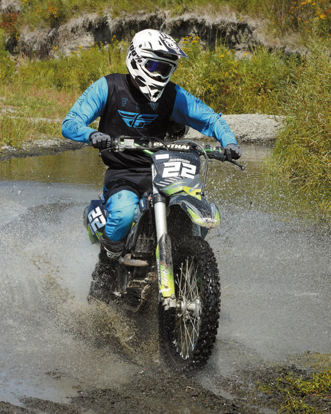 Jacob Johnson makes a splash crossing through the water. Photo by Larry Stokke.