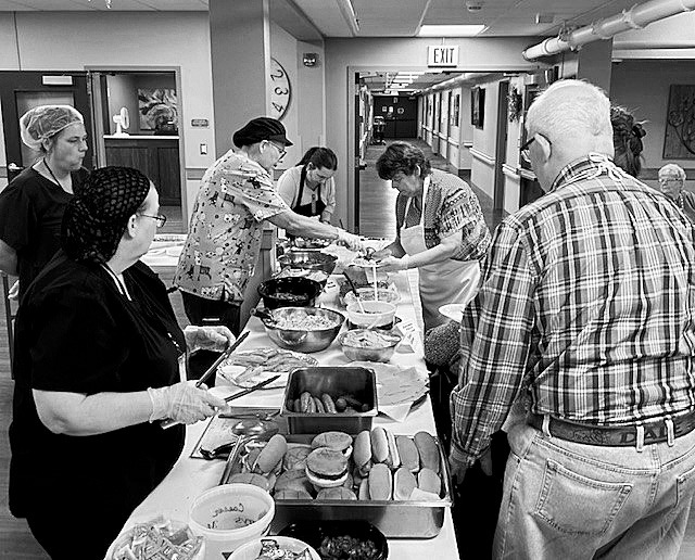 Visitors line up for the delicious potluck dinner.