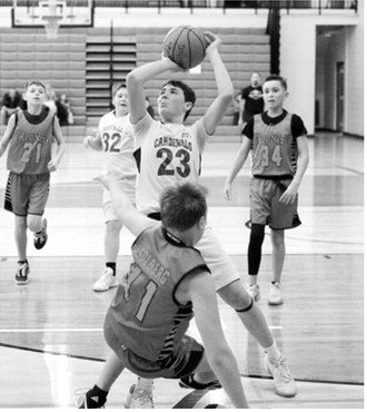 Kyler Hansen drives to the basket and adds two points to the Cards score at the Sports Boosters Tournament in Langdon on Jan. 24. Photo by Larry Stokke
