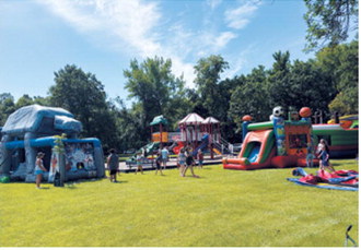 Kids enjoy the inflatable attractions set up in Riverside Park during Walhalla's Fourth of July celebration. Borderland Press Photo