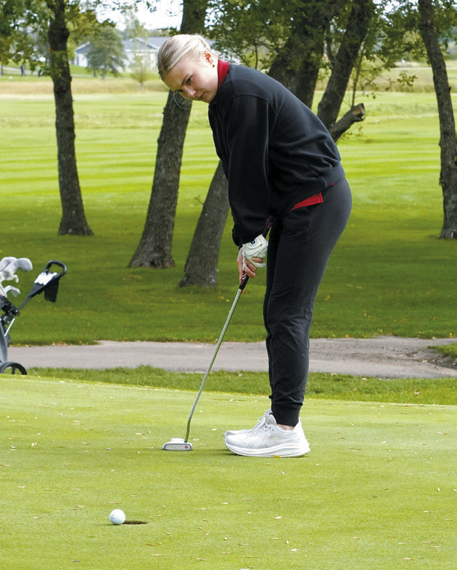 Catelyn Goodman sinks a putt at the Regional Golf Meet in Devils Lake on Sept. 23. Photo by Larry Stokke.