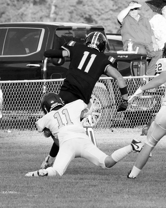 The Eagle's Kolter Kakela tackles #11 Mustang, Ben Gudajtes. Photo by Larry Stokke.