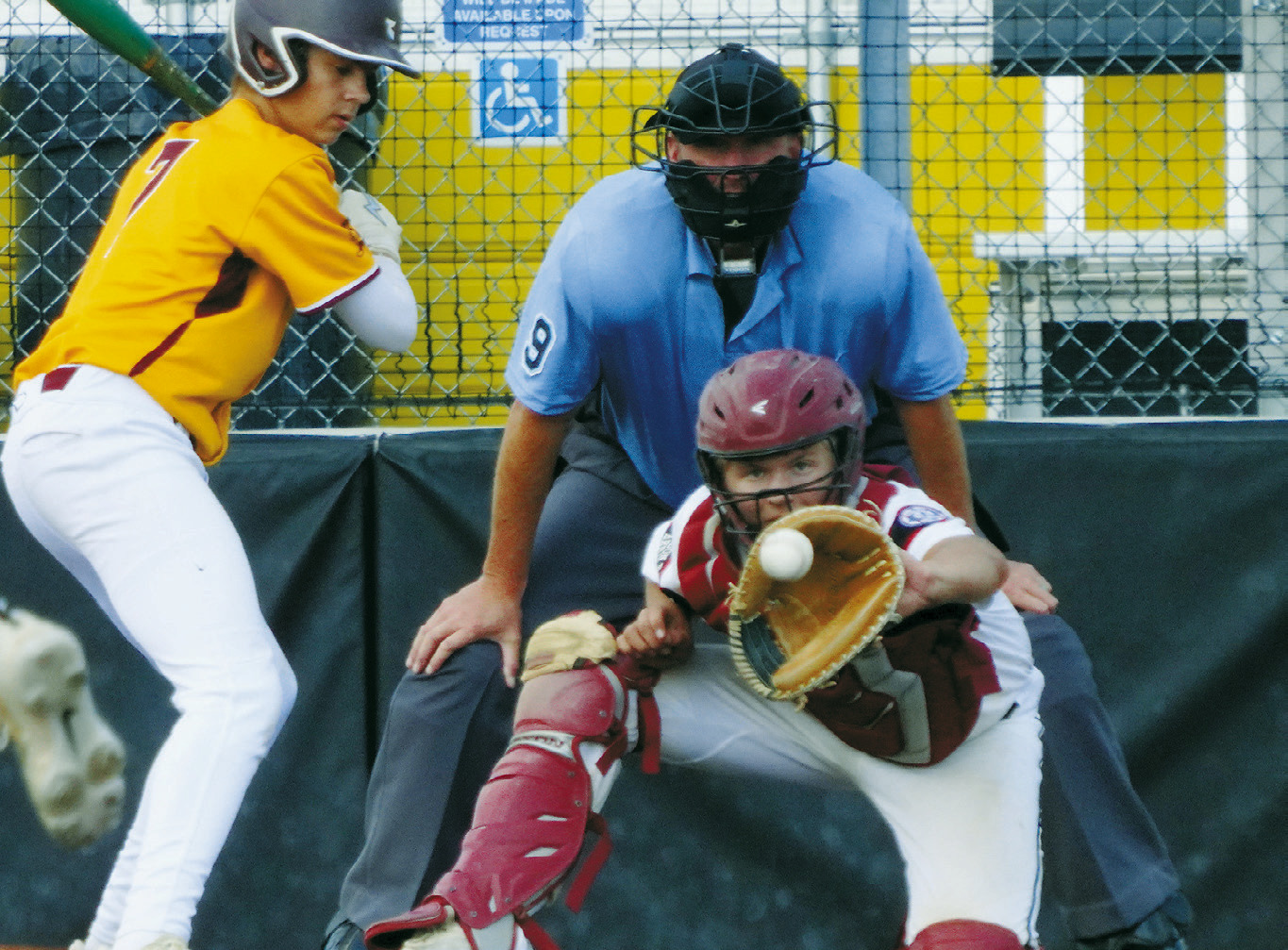 Luke Gilseth eyes the ball and makes a catch behind the plate against Park River. Photo by Larry Stokke.