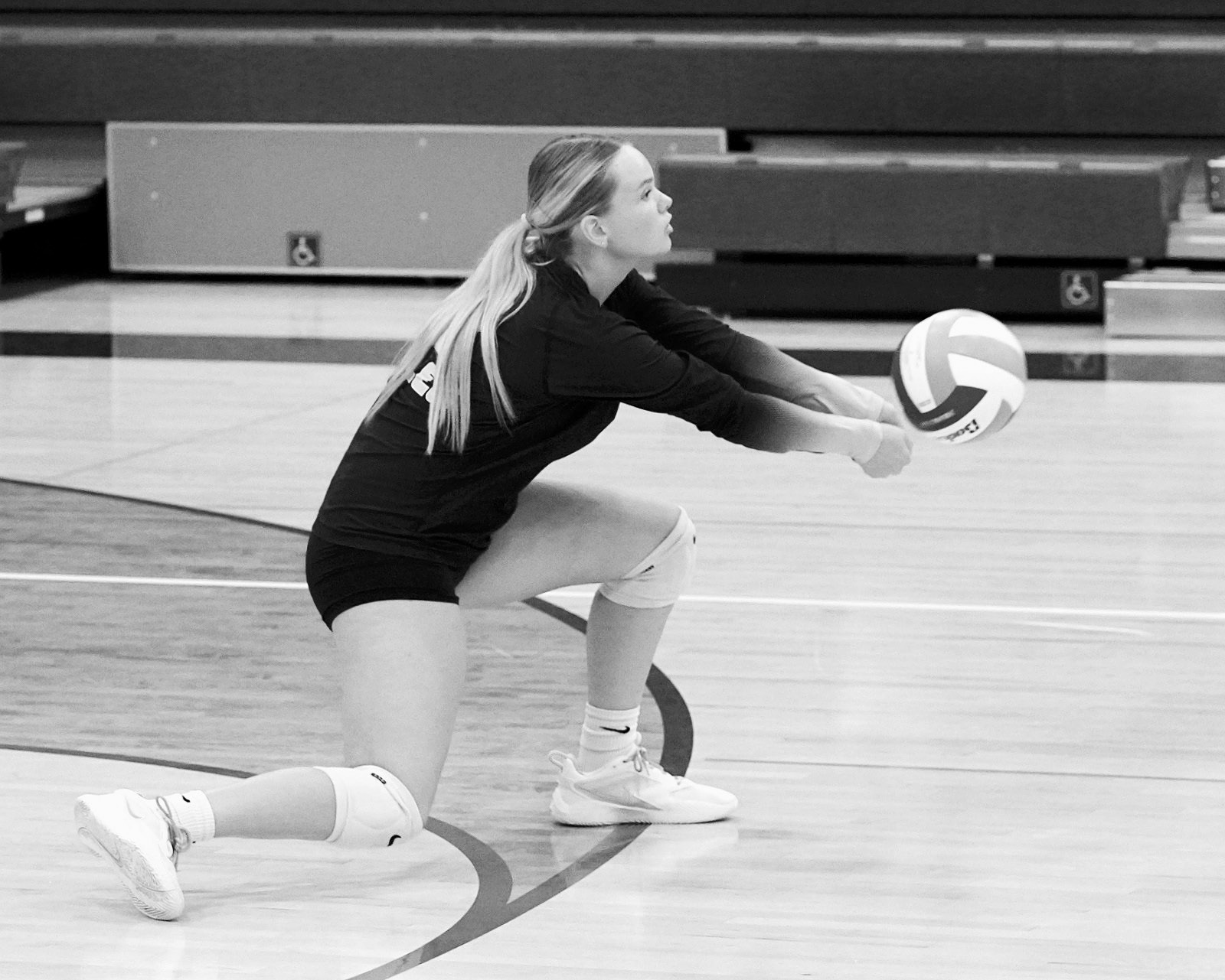 Kate Bjornstad digs the ball from the back row. Photo by Larry Stokke.