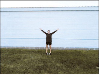 Artist Kassie Zimmer Lee stands before a blank wall on June 11 as work begins on Munich’s new community mural. The project is expected to be unveiled June 24 in conjunction with Munich’s second annual Meat Raffle fundraiser. Submitted photo