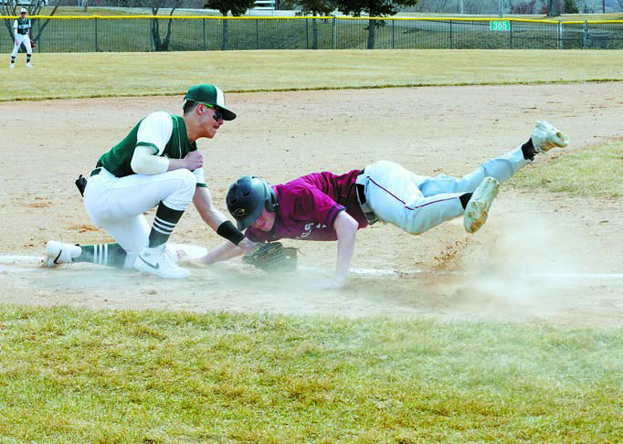 Kadyn Hein makes a dive to get safely back to 3rd base in the win over Hazen April 5th. Photo by Larry Stokke.