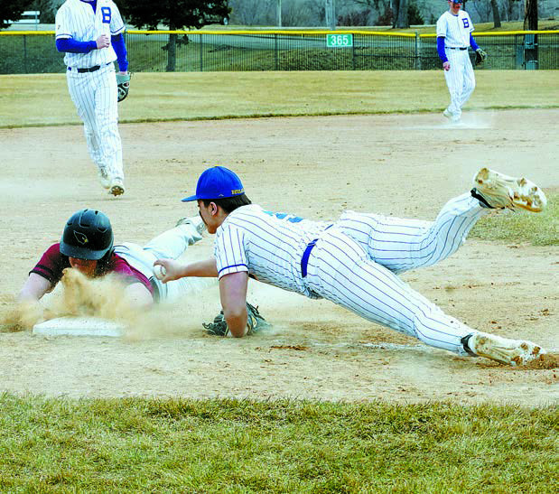 Devin Hakanson dives and beats the tag out by inches in the Cards' win over Beulah on April 5. Photo by Larry Stokke.