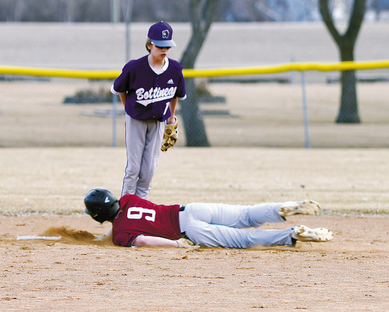 Dawson Downs dives into 2nd base against Bottineau. Photo by Larry Stokke.
