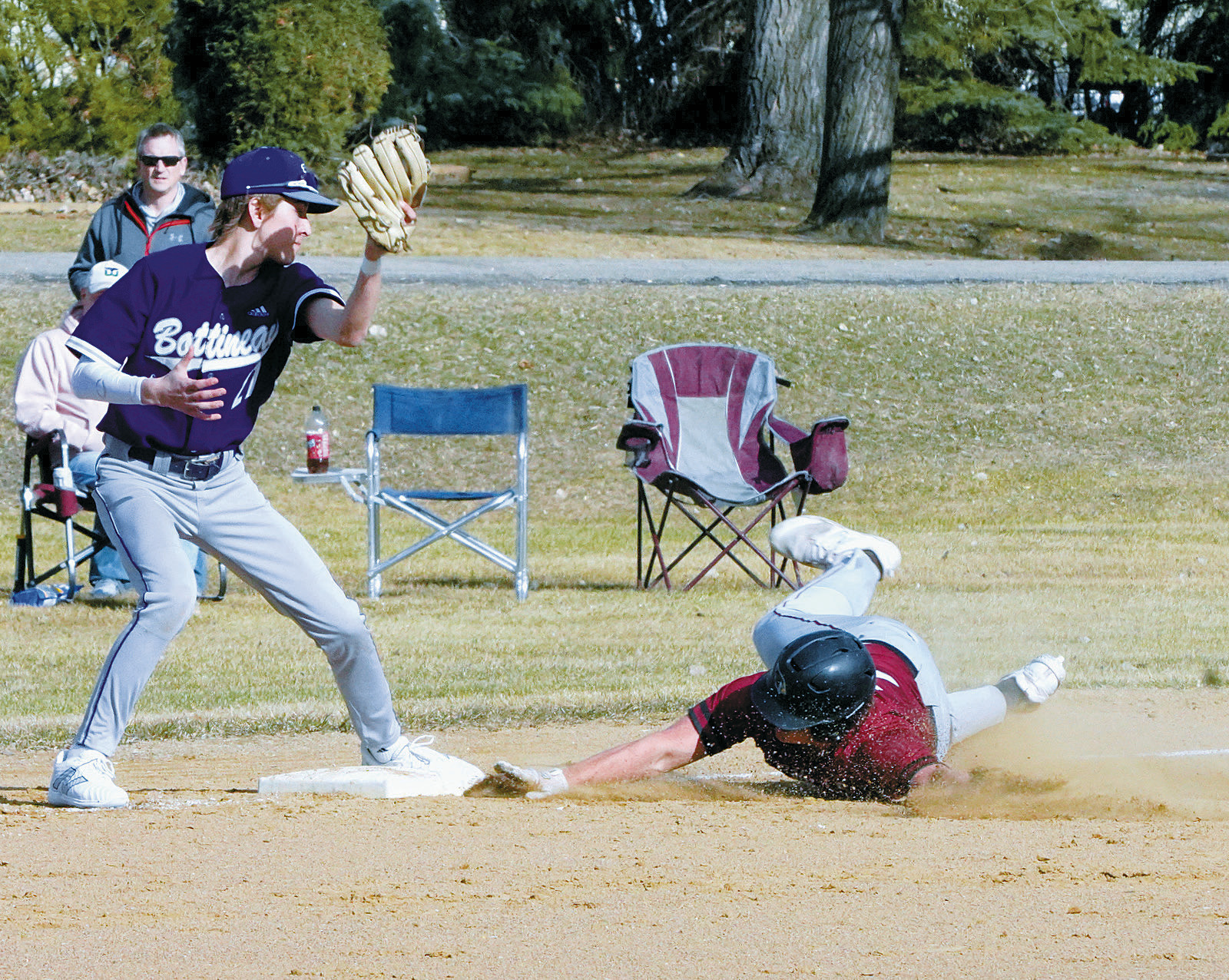 Theo Romfo slides into 3rd base beating the tag out. Photo by Larry Stokke.