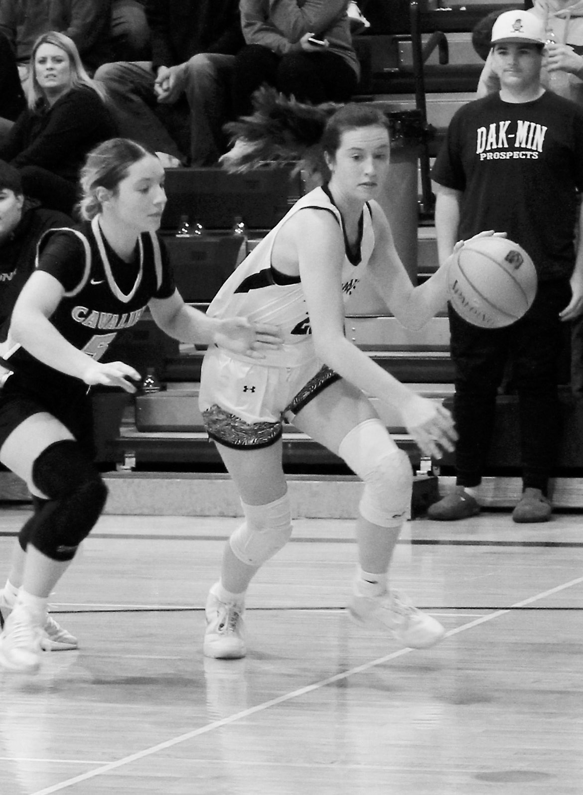 DVE senior Jaelyn Johnson drives the ball toward the basket, passing Cavalier junior Colbie Furstenau. Photo by Jamie Rarick.