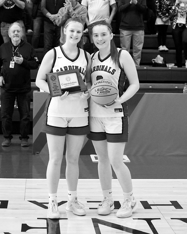 Seniors Mikaela Olson and Meredith Romfo accept the 5th place plaque and game ball. Photo by Larry Stokke.