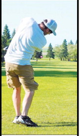 A golfer follows through on a tee shot during the St. Alphonsus School Adult-Child Golf Tournament on July 13 at the Langdon Country Club. Photo by Larry Stokke