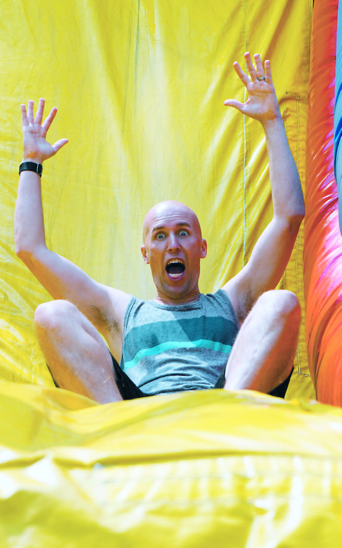 Jordan Braunberger slides down one of the bouncy houses for an annual Music Fest shot. Photo by Larry Stokke.