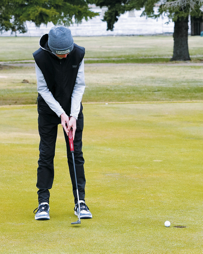 Dyson Askvig finishes a putt during a chilly day at the Dave Osborn Invitational in Cando on May 5. Askvig shot a 90 at the meet. Photo by Larry Stokke