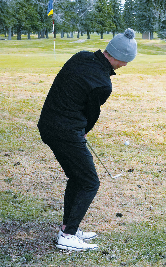 Ryland Peterson chips onto the green during the Dave Osborn Invitational in Cando on May 5. Photo by Larry Stokke