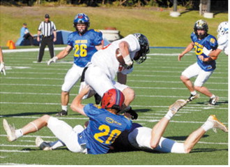Sam Davis, No. 20, and a teammate stop a West team ball carrier for no gain during the Shrine Bowl on June 20. Photo by Larry Stokke