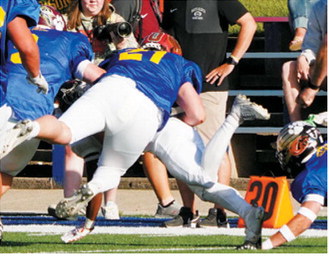 Theo Romfo makes a diving tackle to stop a West team player short of a first down during the Shrine Bowl on June 20. Photo by Larry Stokke