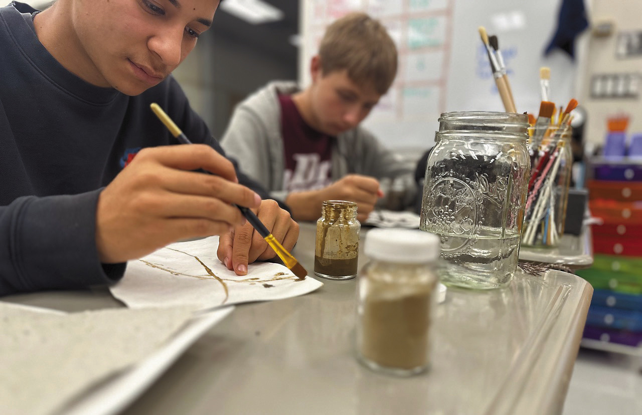 North Valley CTE students Isidoro Martinez (left) and Aaron Linner paint with soil pigments on prairie paper as part of the Thinking Like a Prairie workshops. Photo provided by Josh Anderson.