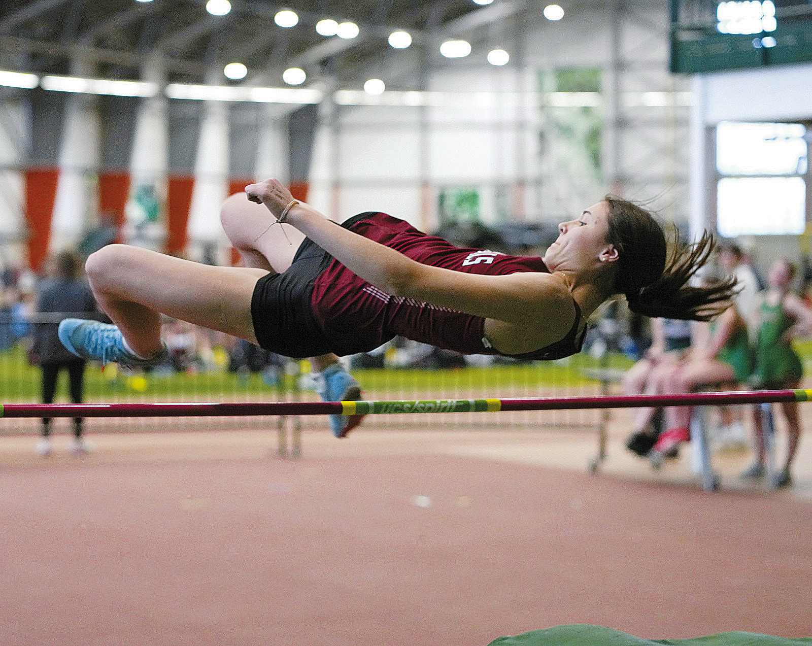 Taya Feist clears the high jump with room to spare at the Green Wave Meet on April 19. Photo by Larry Stokke.